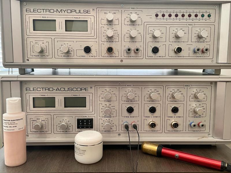 two microcurrent therapy machines, stacked, top one labeled 'electro-myopulse', the bottom labeled 'electro-acuscope'